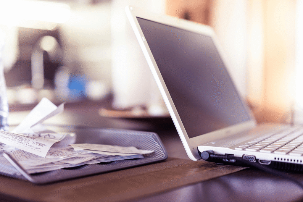 Receipts next to laptop for manual expense capturing
