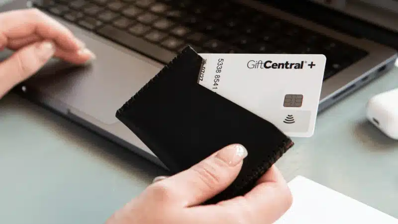 GiftCentral Plus card held above reward envelope on desk workspace